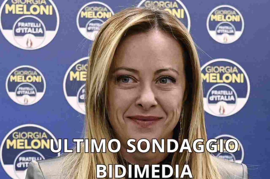 La Premier Giorgia Meloni e sfondo con simboli del partito FdI